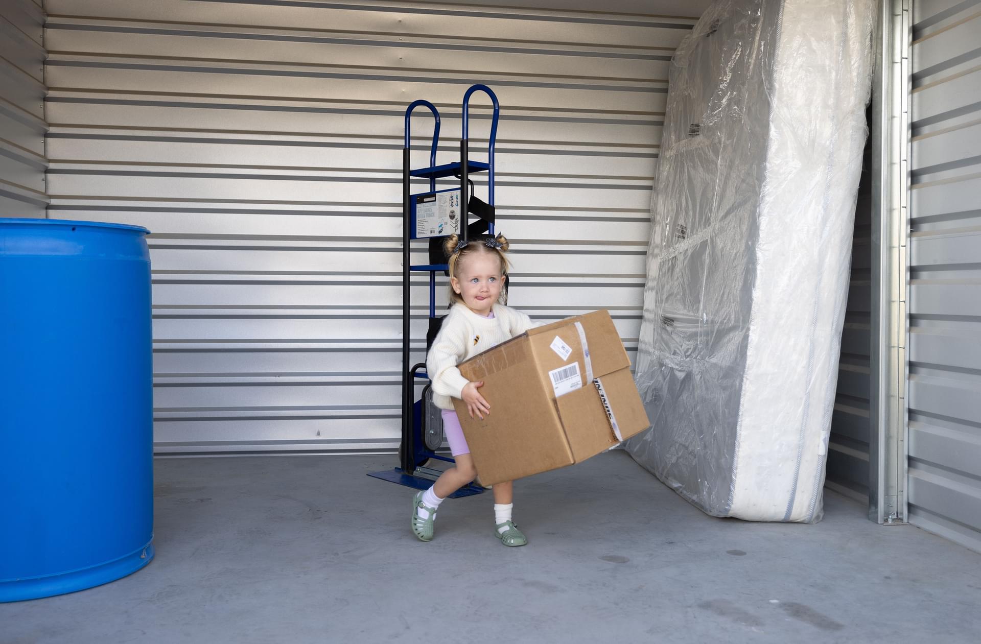 child helping carry moving box