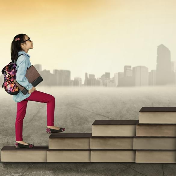  Girl climbing up stairs made of books 