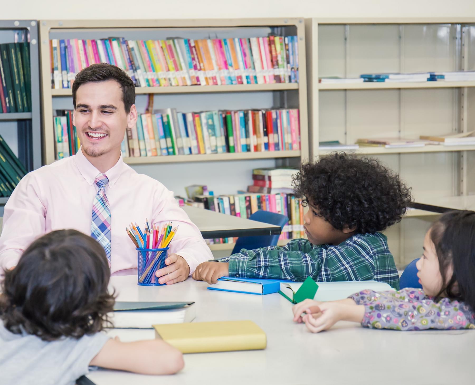 Students at a table with a teacher