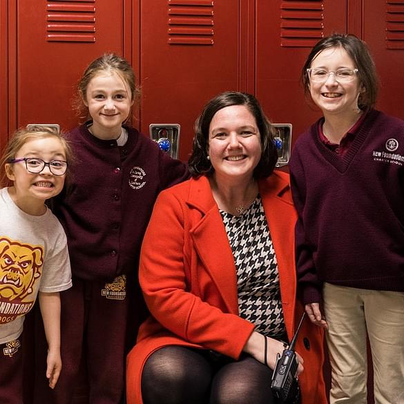 Principal smiling with young students