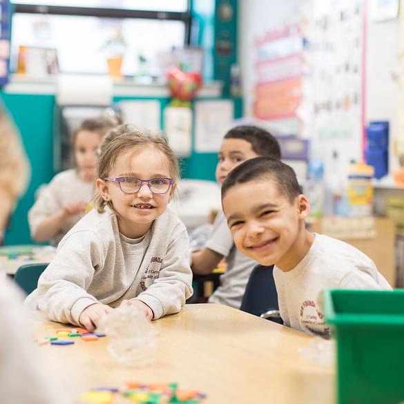 2 young students smiling in class