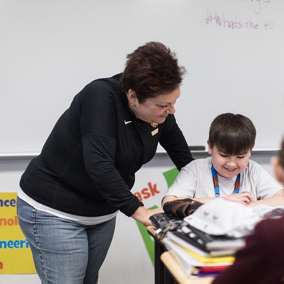  Teacher looking over student's shoulder at his work 