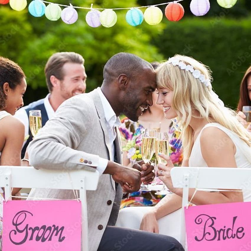 Couple smiles and shares a drink at their wedding party