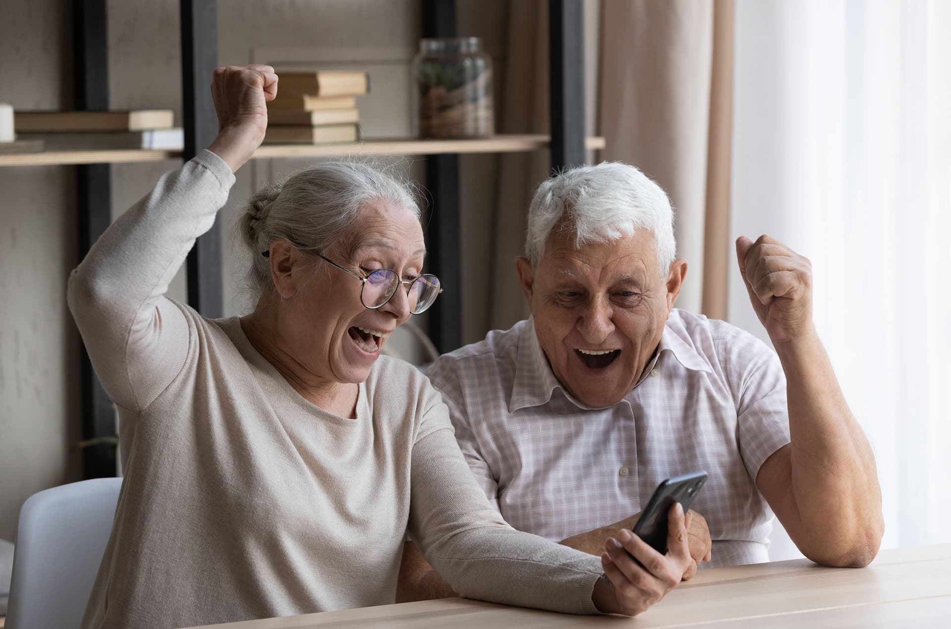 Couple cheering while looking at their phone