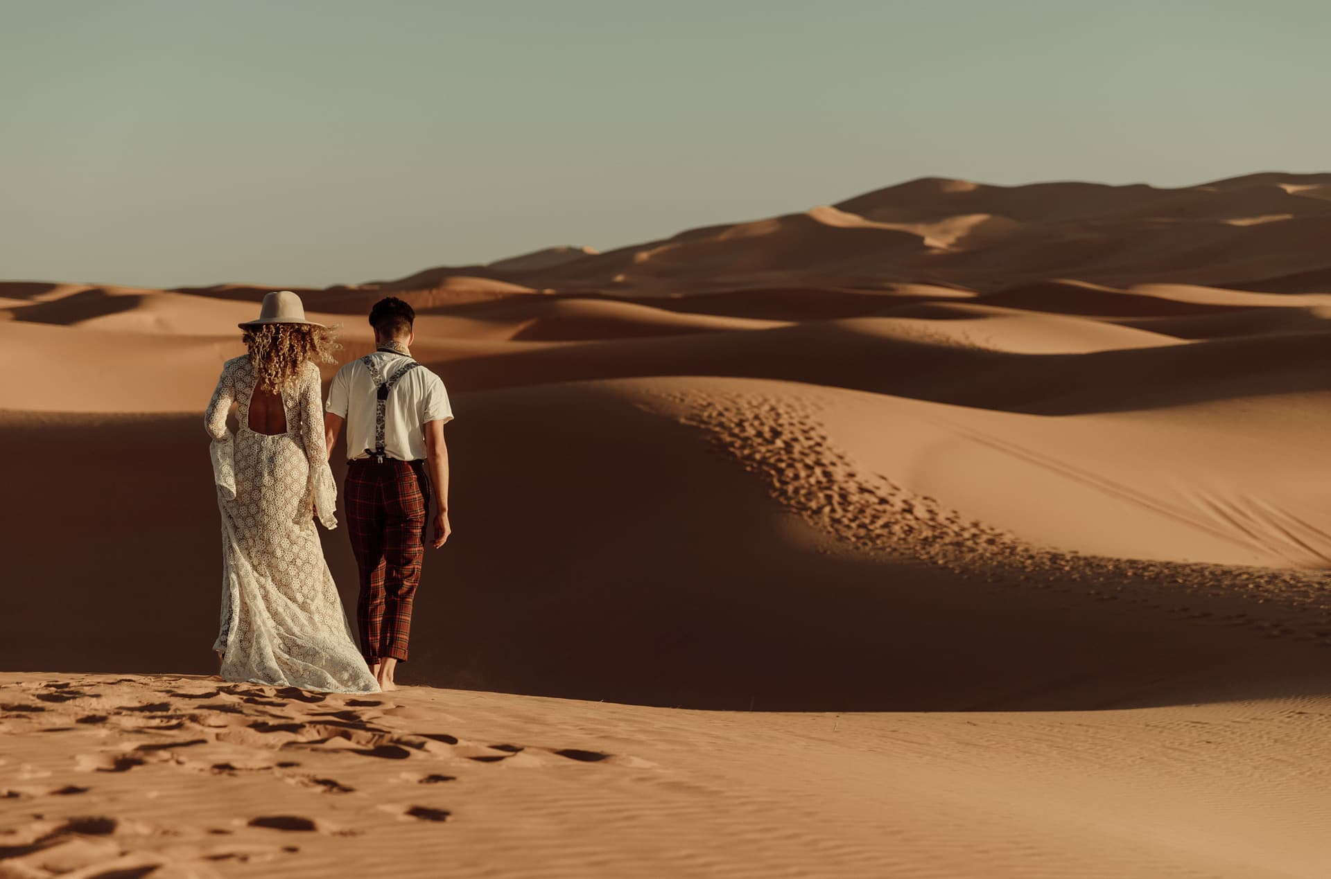 Married couple walks through a desert