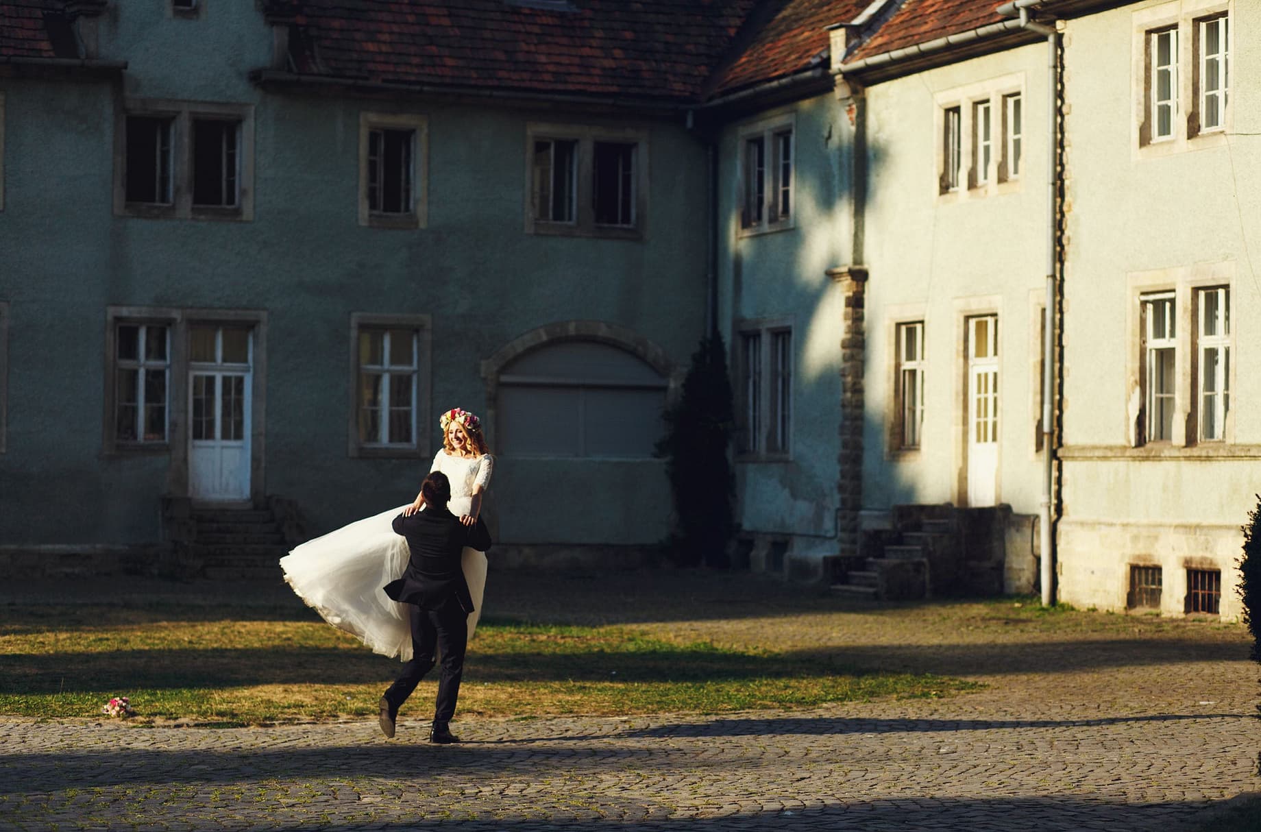 Married couple dance and spin around a courtyard