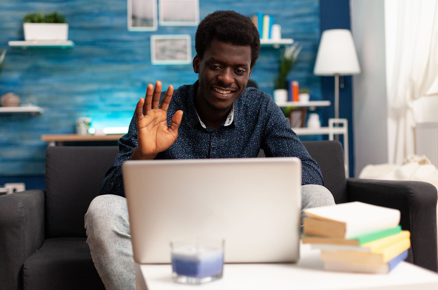 A man waves to his long-distance partner via video call