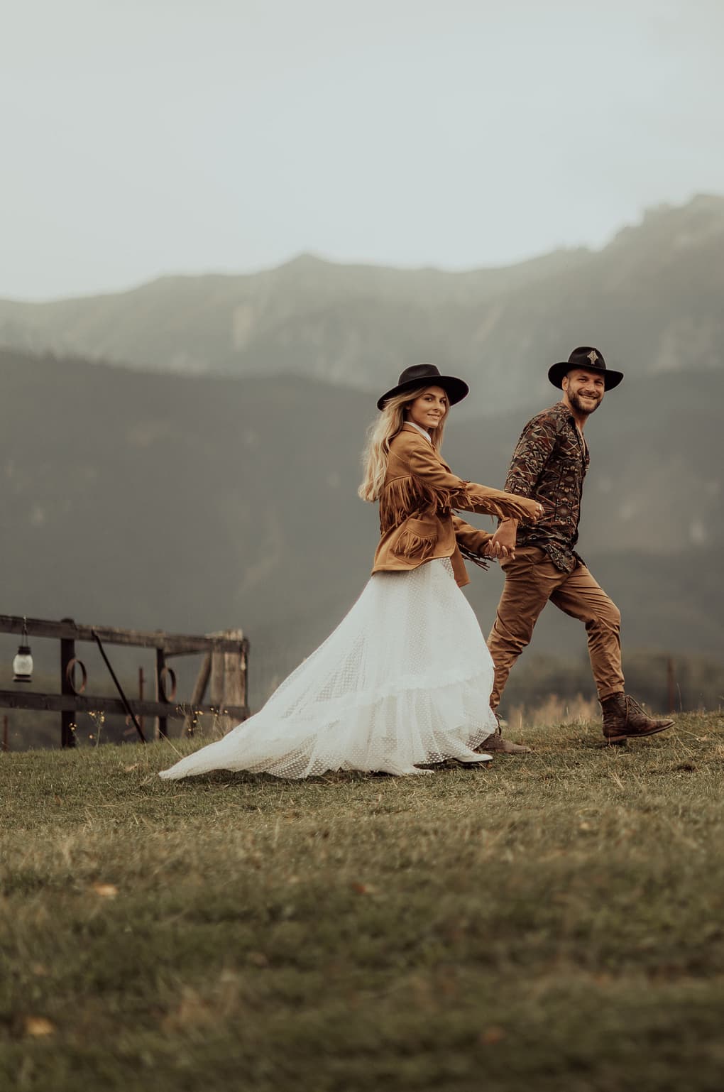 Couple smiles and walks on a mountainside