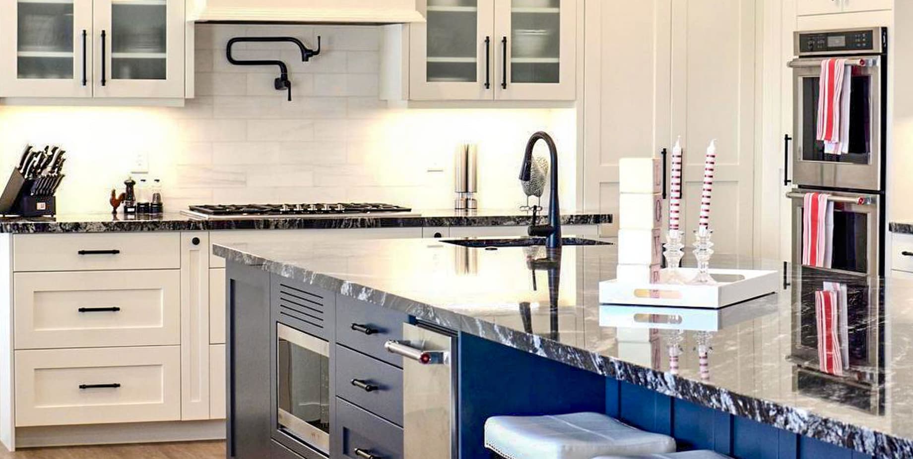 Stunning kitchen with tile black splash and navy blue island as an accent