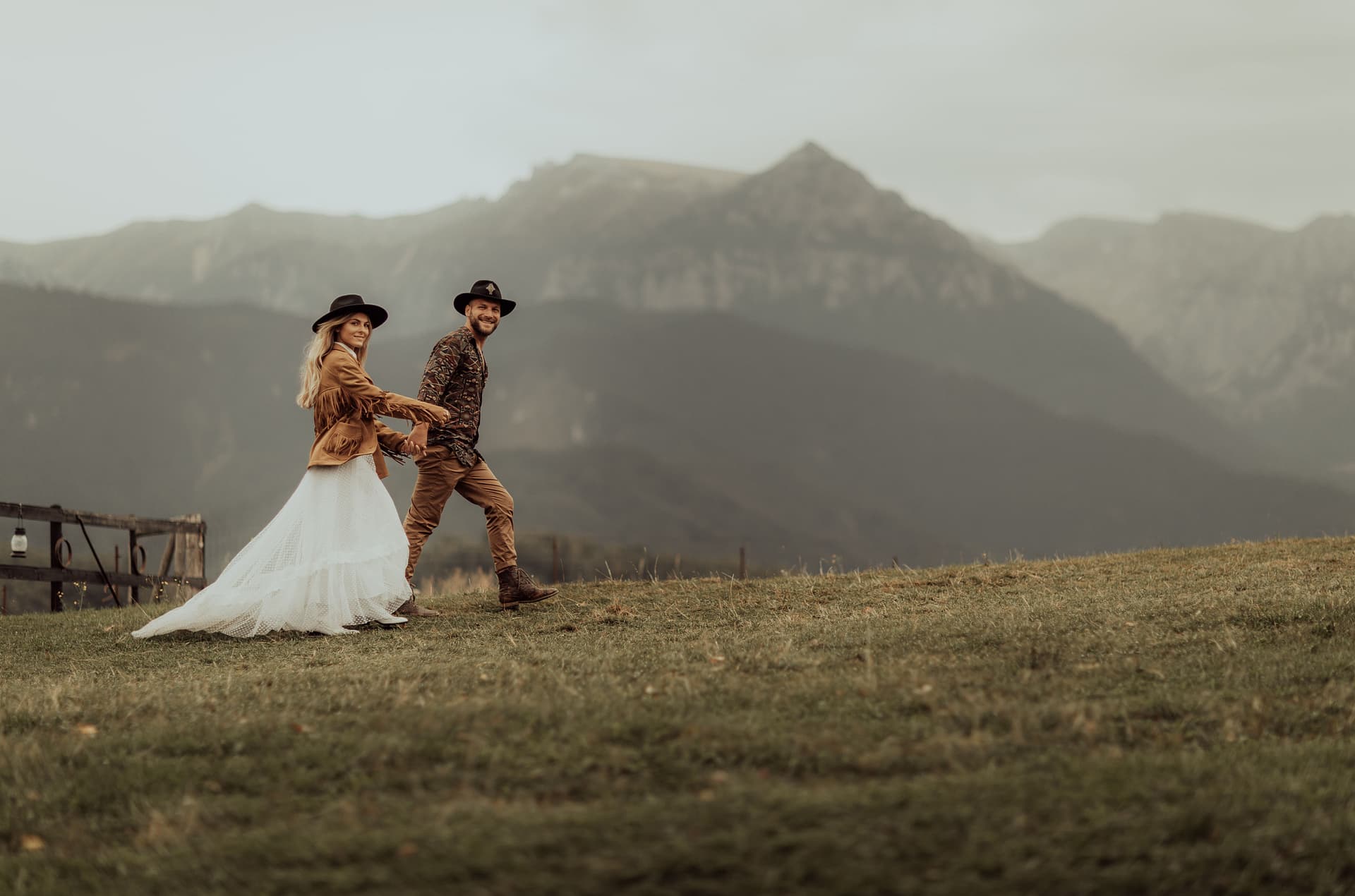 Couple smiles and walks on a mountainside