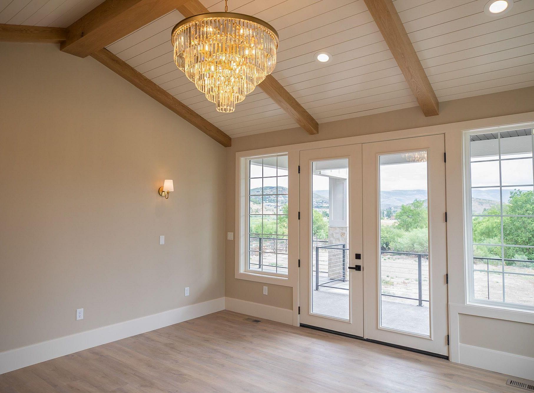 Primary bedroom with exposed beams and mountain views at the Springbrook custom home in Midway, Utah