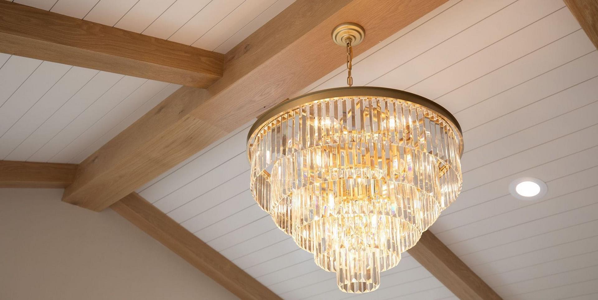 Primary bedroom ceiling with exposed beams and a custom chandlier at the Springbrook custom home in Midway, Utah