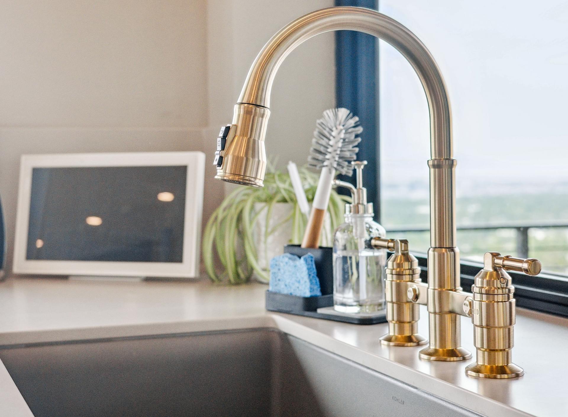 Kitchen sink with arched faucet and brass fixtures overlooking Salt Lake City.
