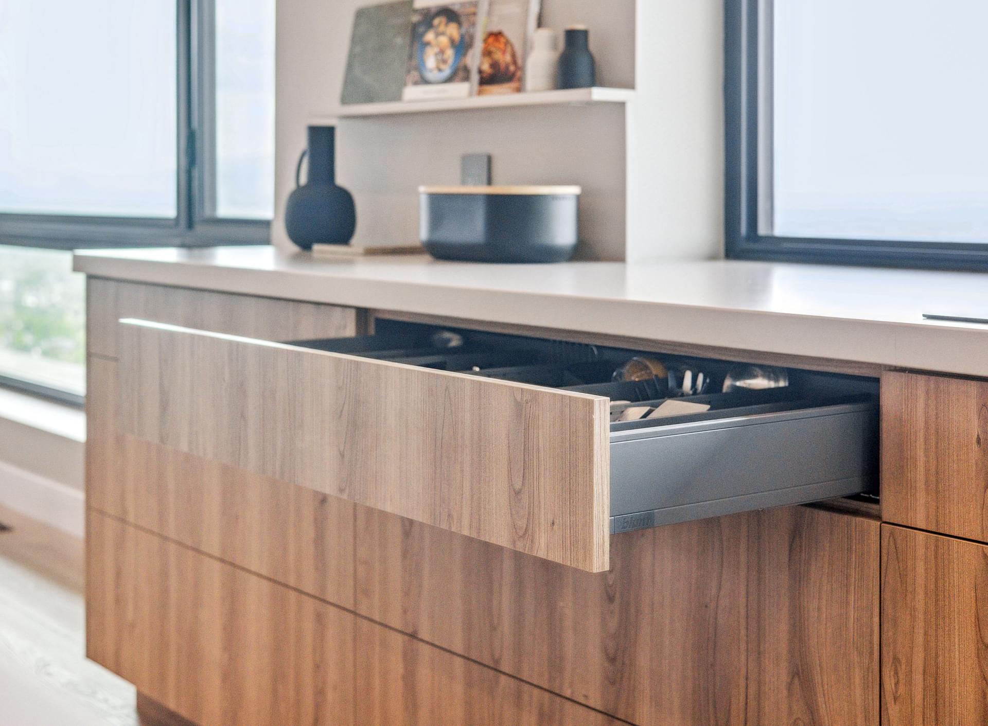 Wood kitchen island with waterfall countertop and built-in storage.