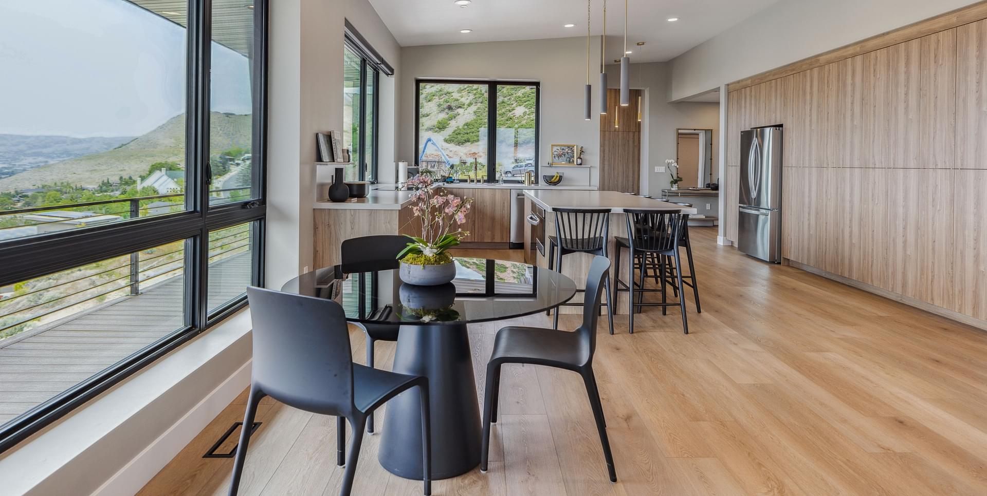 Open dining and kitchen area with large windows and mountain views in Salt Lake City.