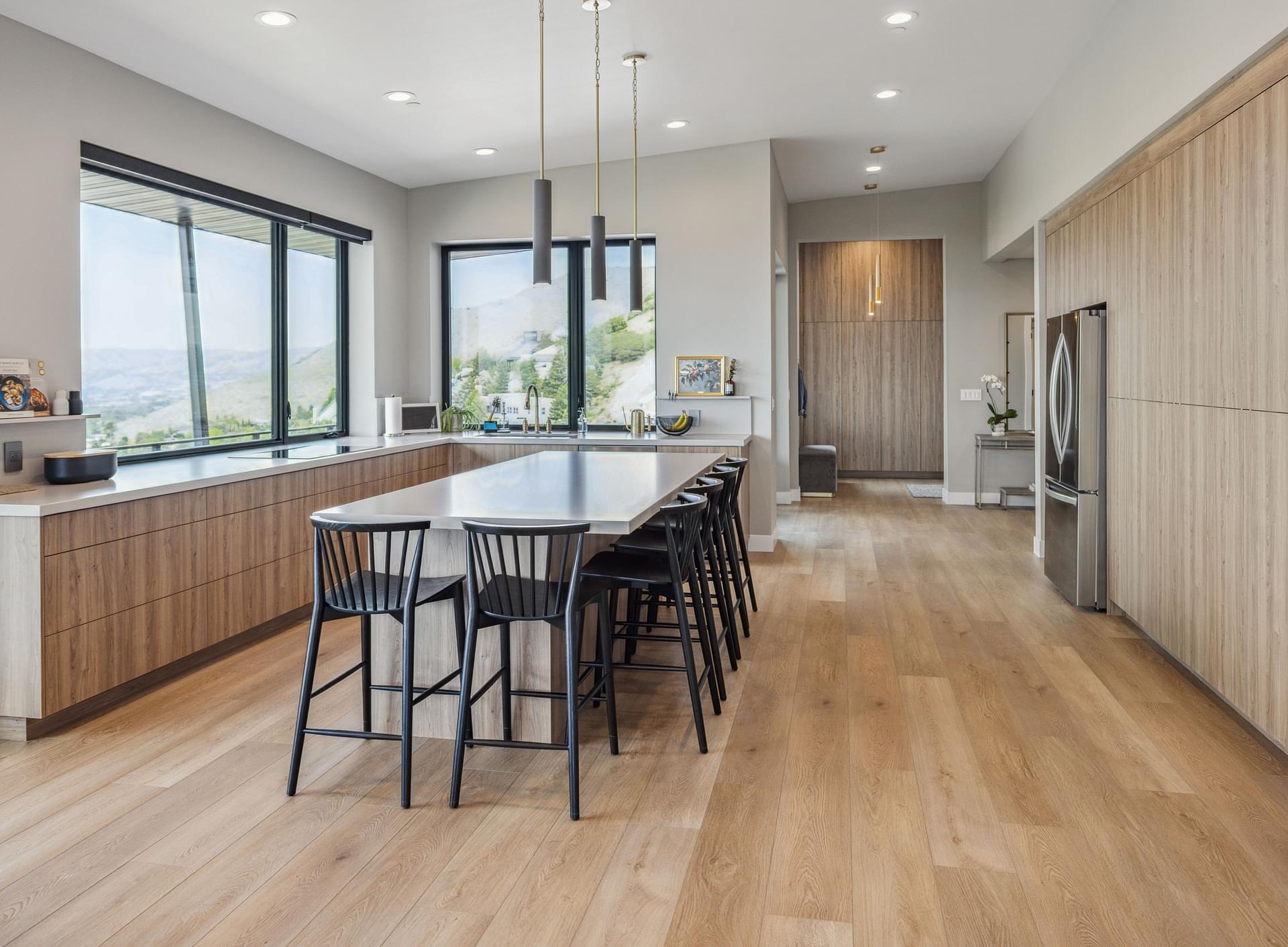 Stainless steel refrigerator integrated into custom wood kitchen cabinetry.