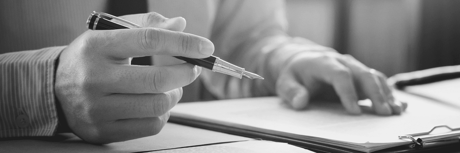 Hands holding pen and writing in accounting book