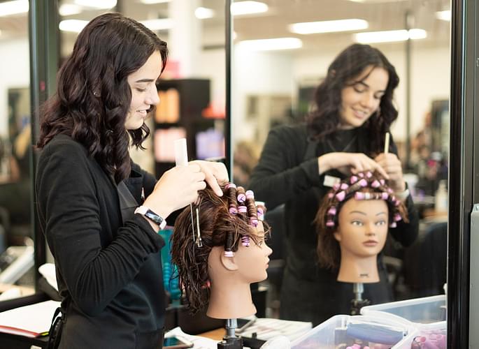 Cosmetology student performing a perm