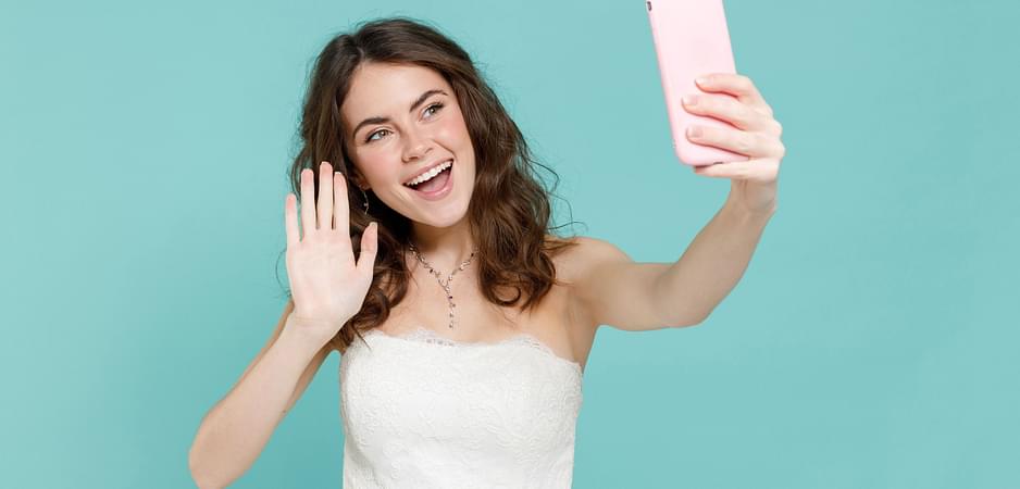 Woman smiles and waves to her partner over video call