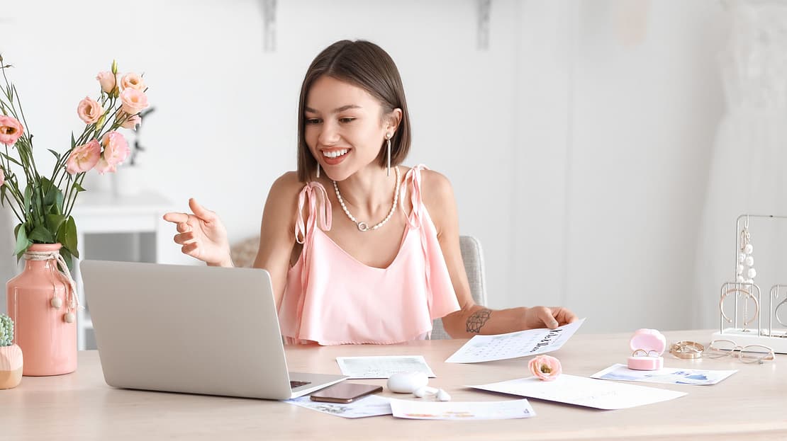  A woman looks at her laptop while making wedding invitations 