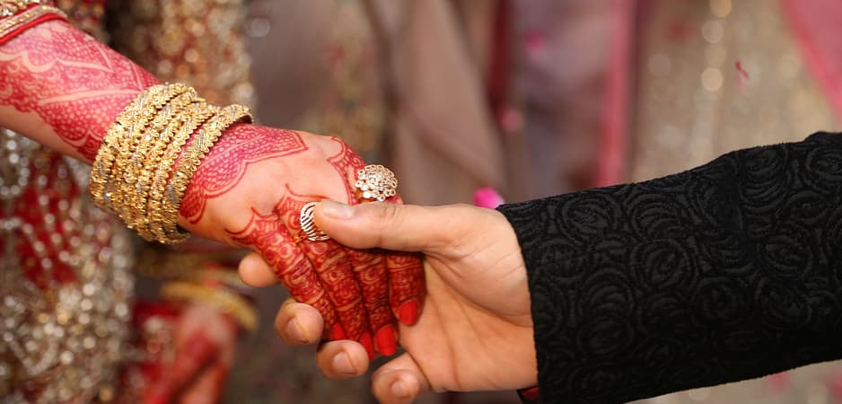 International couples holding hands during wedding