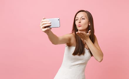 Wife sending kisses to husband through the phone after getting married online.