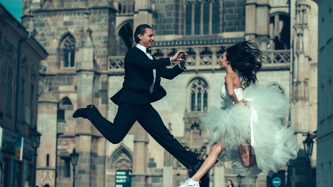  Groom takes a picture of his wife jumping in her wedding dress 