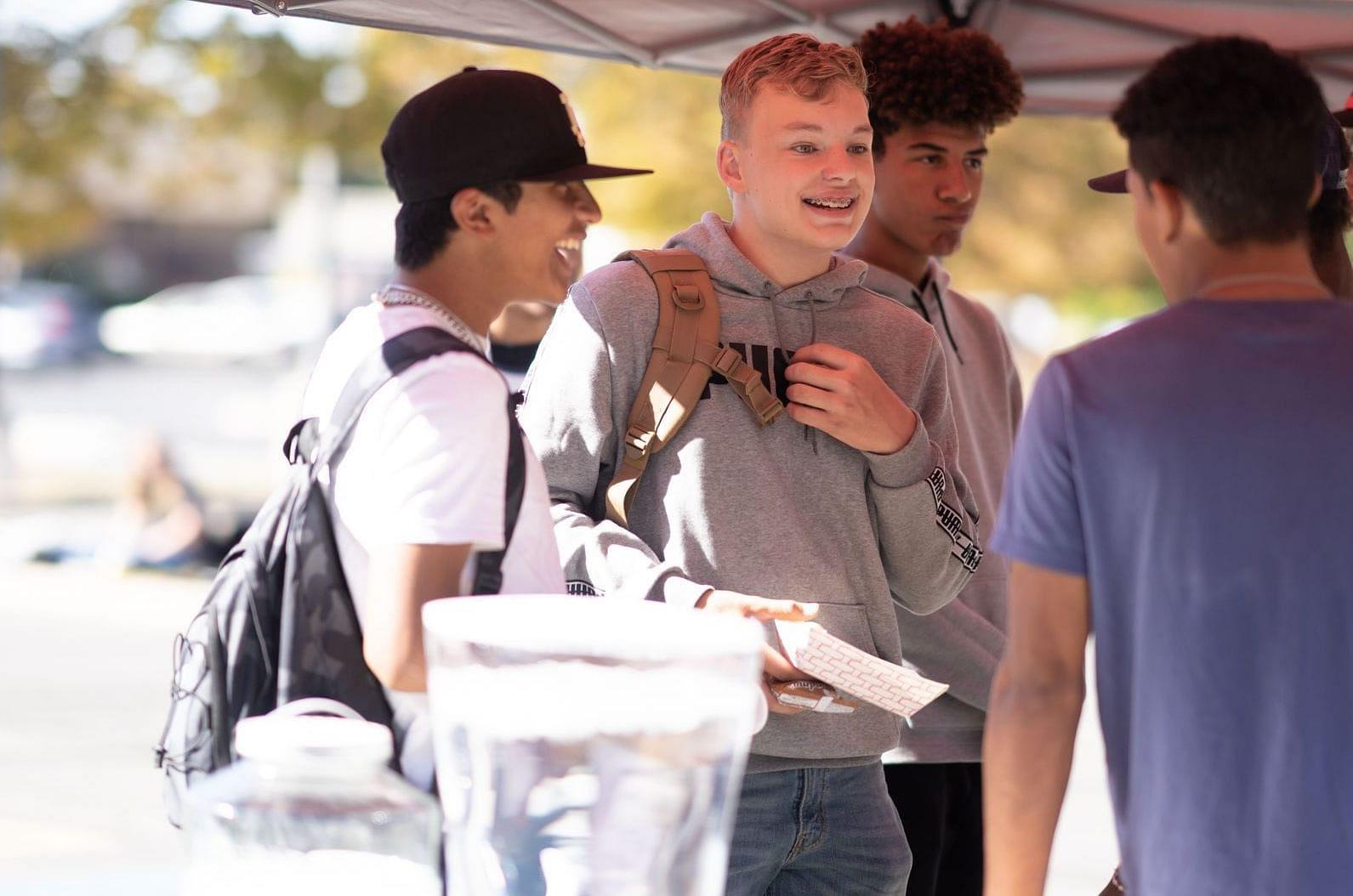 students talking and laughing standing outside