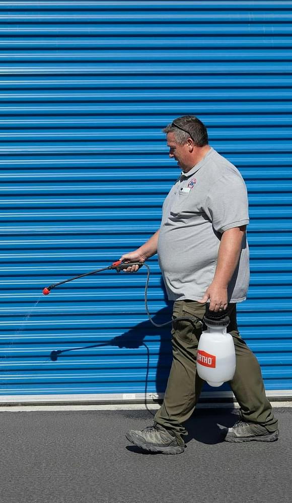 man cleaning entrances of storage units