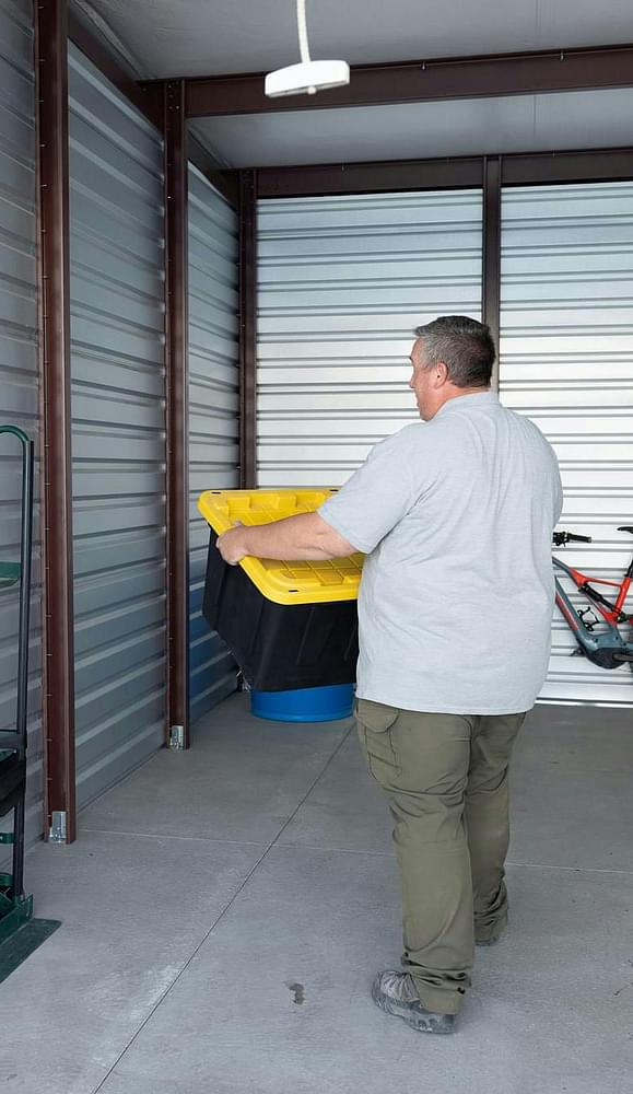 man sitting behind desk renting storage unit to someone